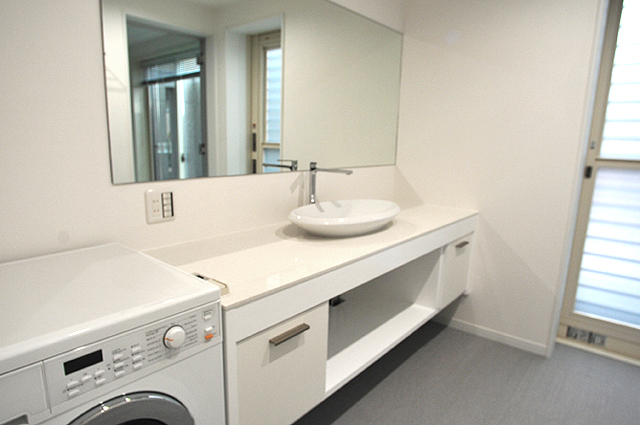 RC造の家 洗面台は創作特注、巾いっぱいの大きな鏡張り